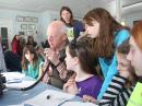 Skip Youngberg, K1NKR (center), establishes an HF contact as (seated, L-R) Annie T., Rowan C., Sophia G., Sophie, and Quincy B. look on. [Ralph Swick, KD1SM, photo]